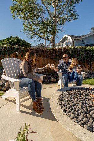 backyard artificial turf family by fire pit